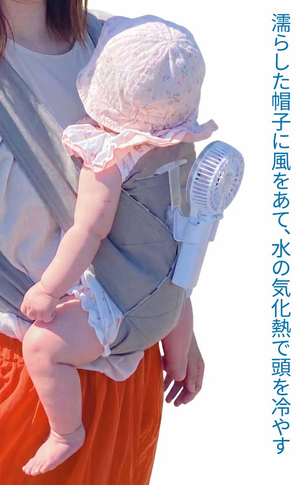 抱っこ紐で抱っこされる赤ちゃんの頭に水で濡らした帽子をかぶせて抱っこ紐の背中につけた扇風機で風をあてて水の気化熱で帽子を冷やして頭を冷やす様子